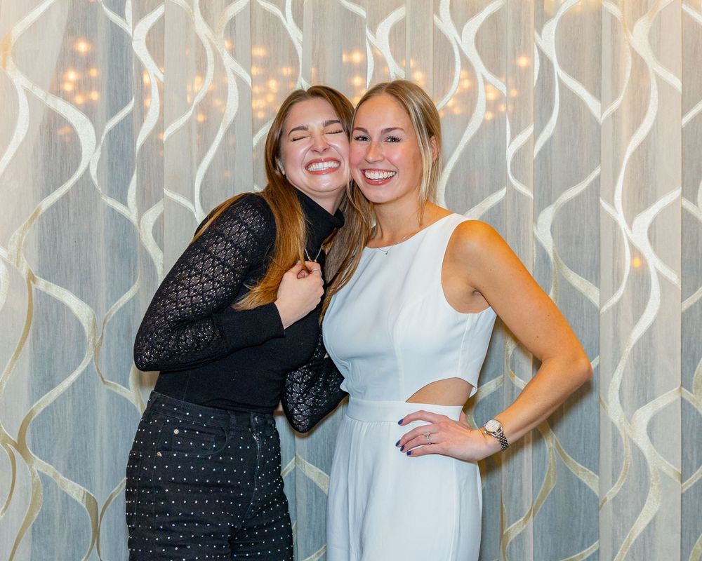Friends posing for a photo in front of a decorative curtain at an engagement party at Arturo's restaurant in Westborough, MA