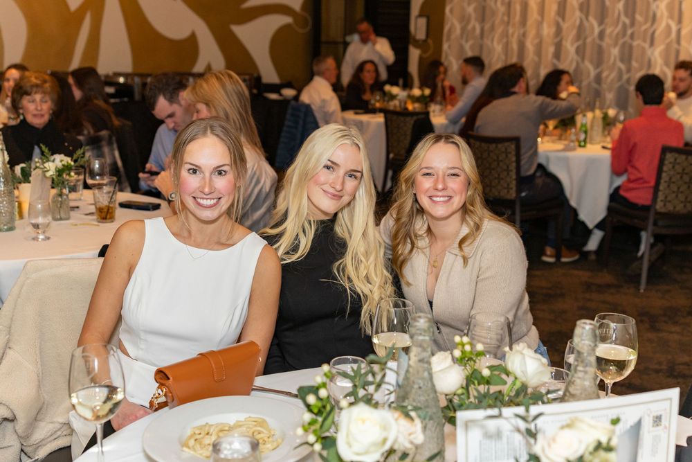 Three guests seated at an elegantly decorated wedding reception table  during engagement party in Westborough, MA.  Event Photography