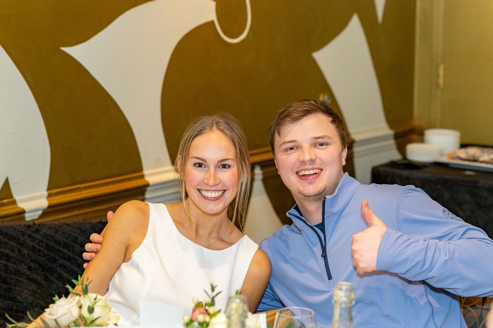 Two guests posing together at formal event with decorative wall backdrop during engagement party in Westborough, MA.  Event Photography