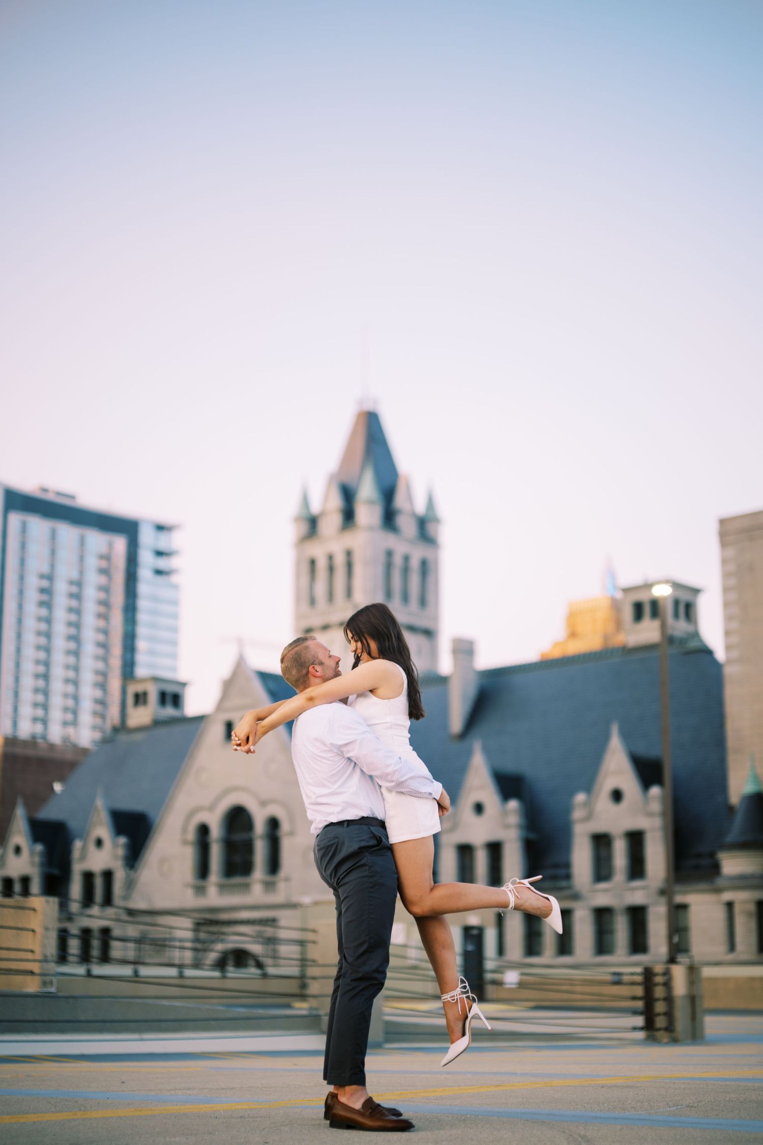 Romantic moment captured in front of historic church architecture with spired towers in downtown setting at dusk.