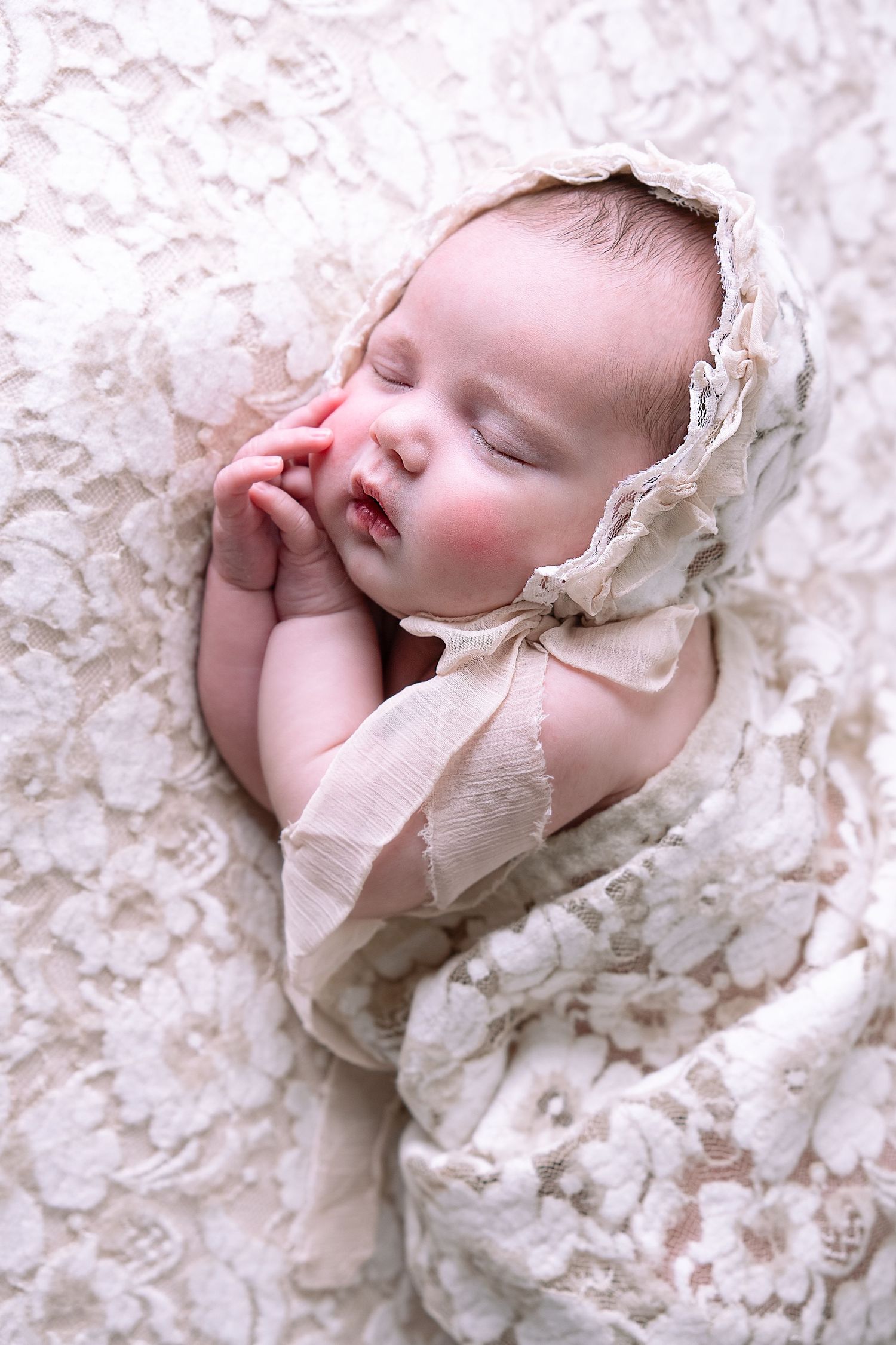 Baby girl in a floral lace wrap and bonnet