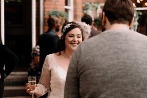 A candid moment at a wedding reception as guests socialize and celebrate with drinks outdoors.