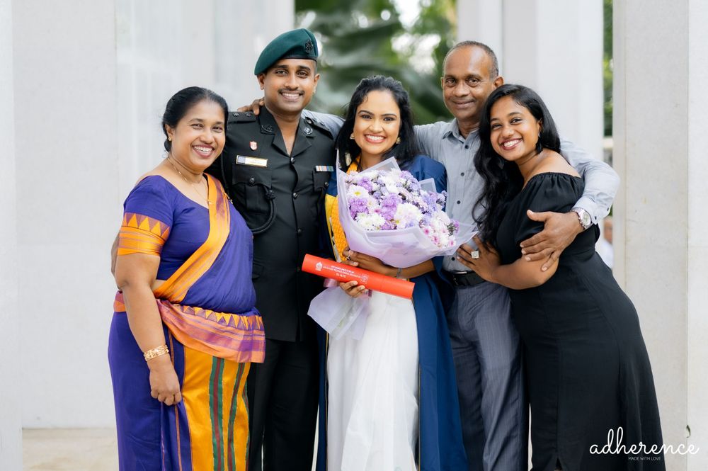 Group celebration photo featuring mix of formal attire, traditional dress, and military uniform.