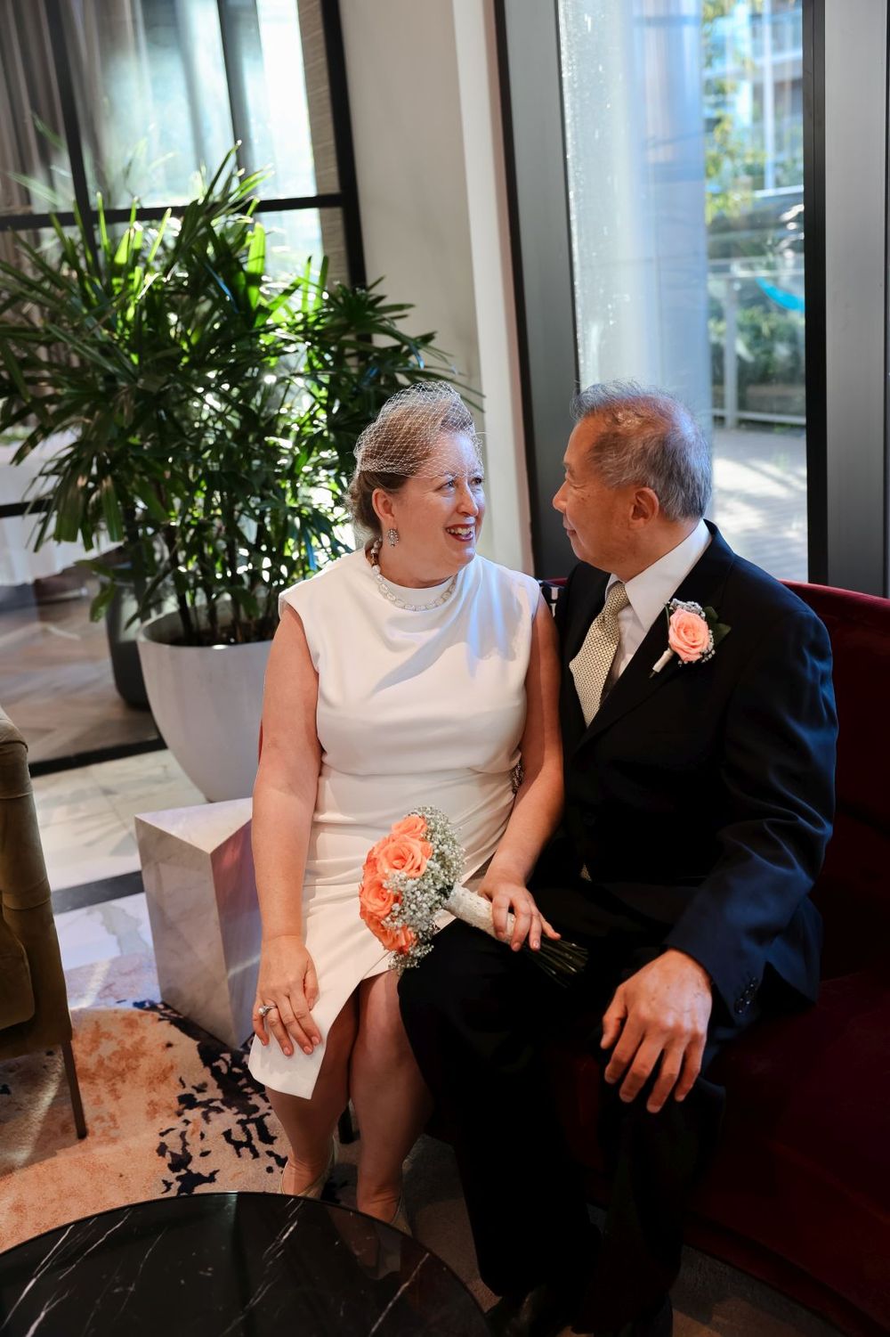 An intimate moment captured at a wedding celebration with peach floral details and elegant attire.
