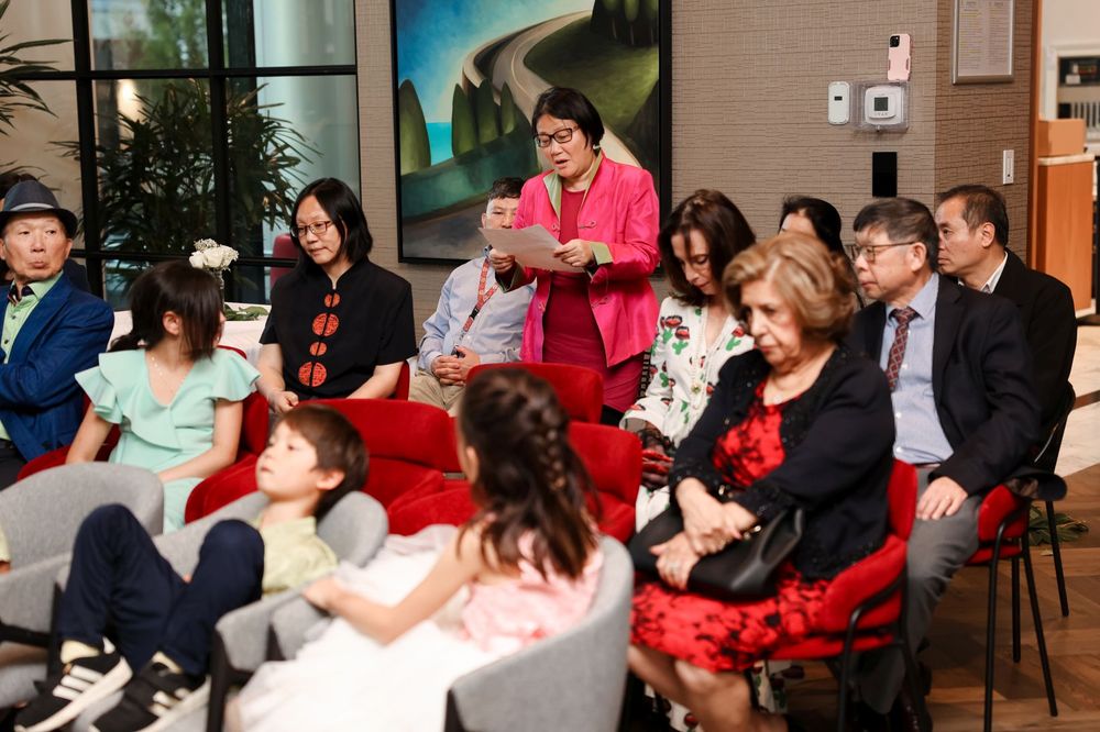 Wedding guests in colorful attire gathered in modern venue seating.