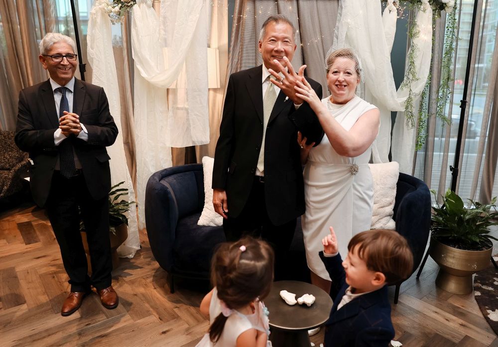 Candid celebration moment at a wedding with white drapery backdrop.