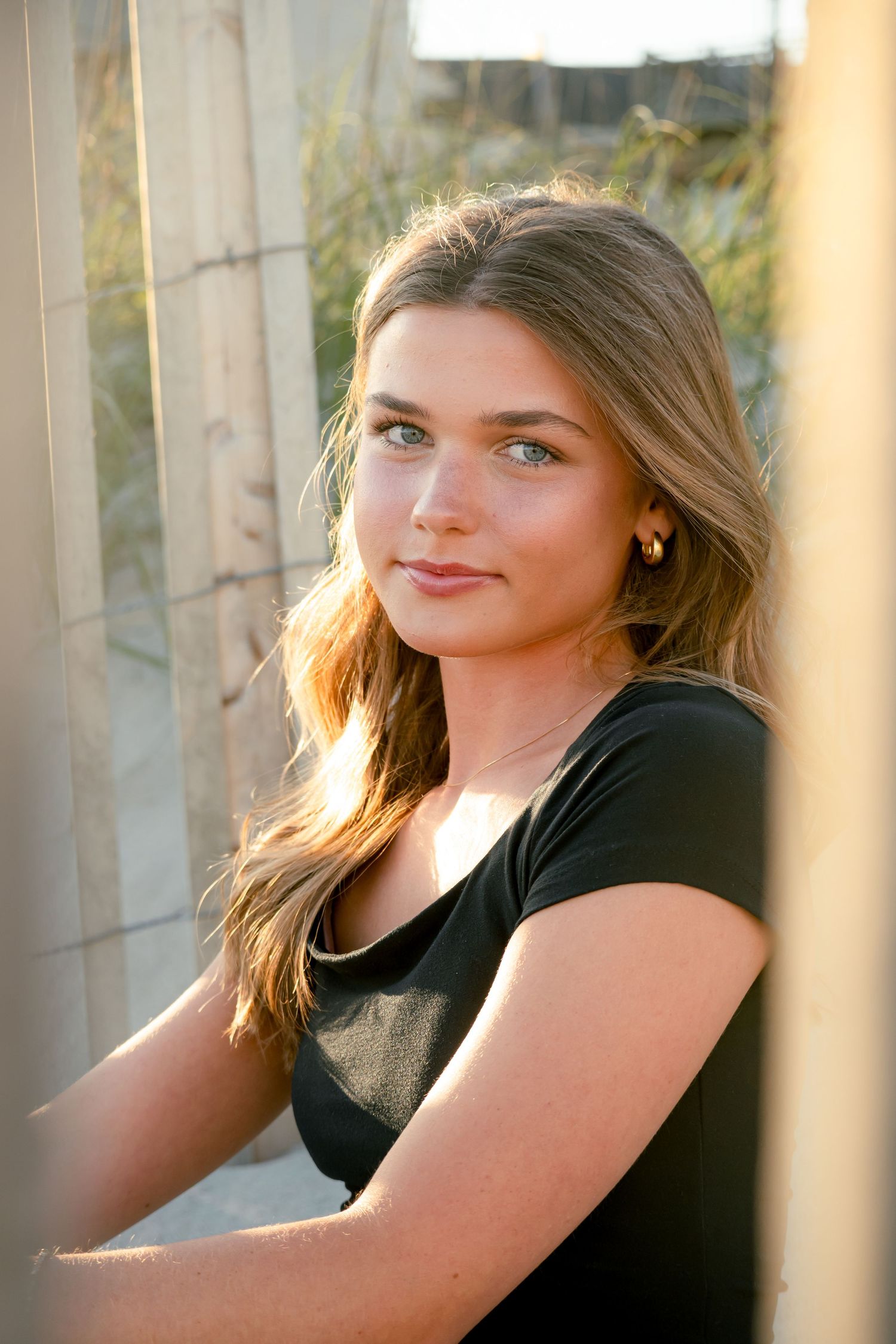 Sunset portrait of someone in a black shirt against a light background.