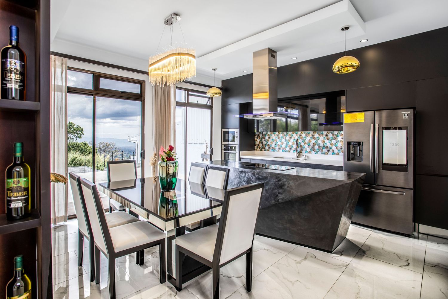 Stylish dining area connected to a state-of-the-art kitchen, adorned with elegant lighting fixtures and panoramic views