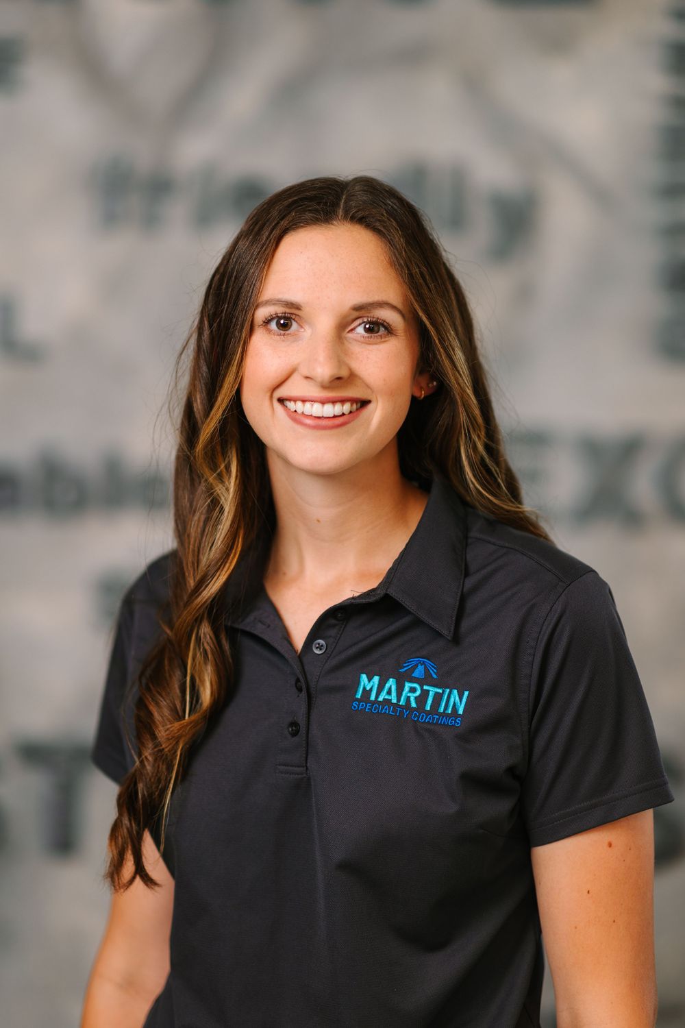 Professional wearing black polo shirt with blue Martin logo against textured gray background.