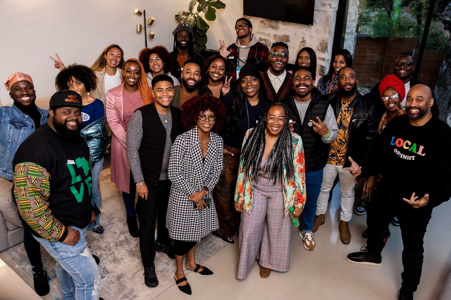 Large group of party guests gathered together for a group photo at an indoor event.