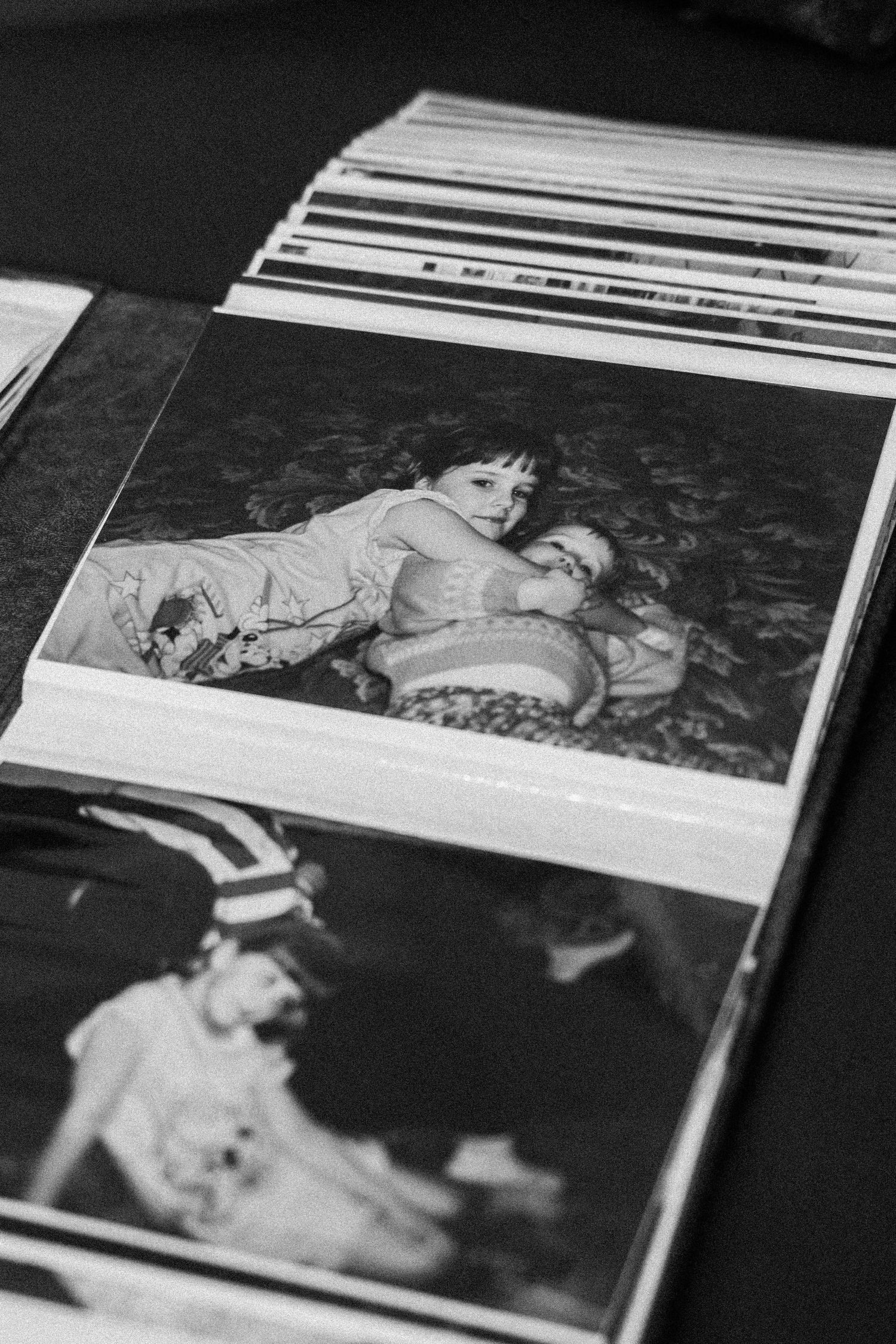 A stack of vintage black and white photographs showing candid captured moments from the past.