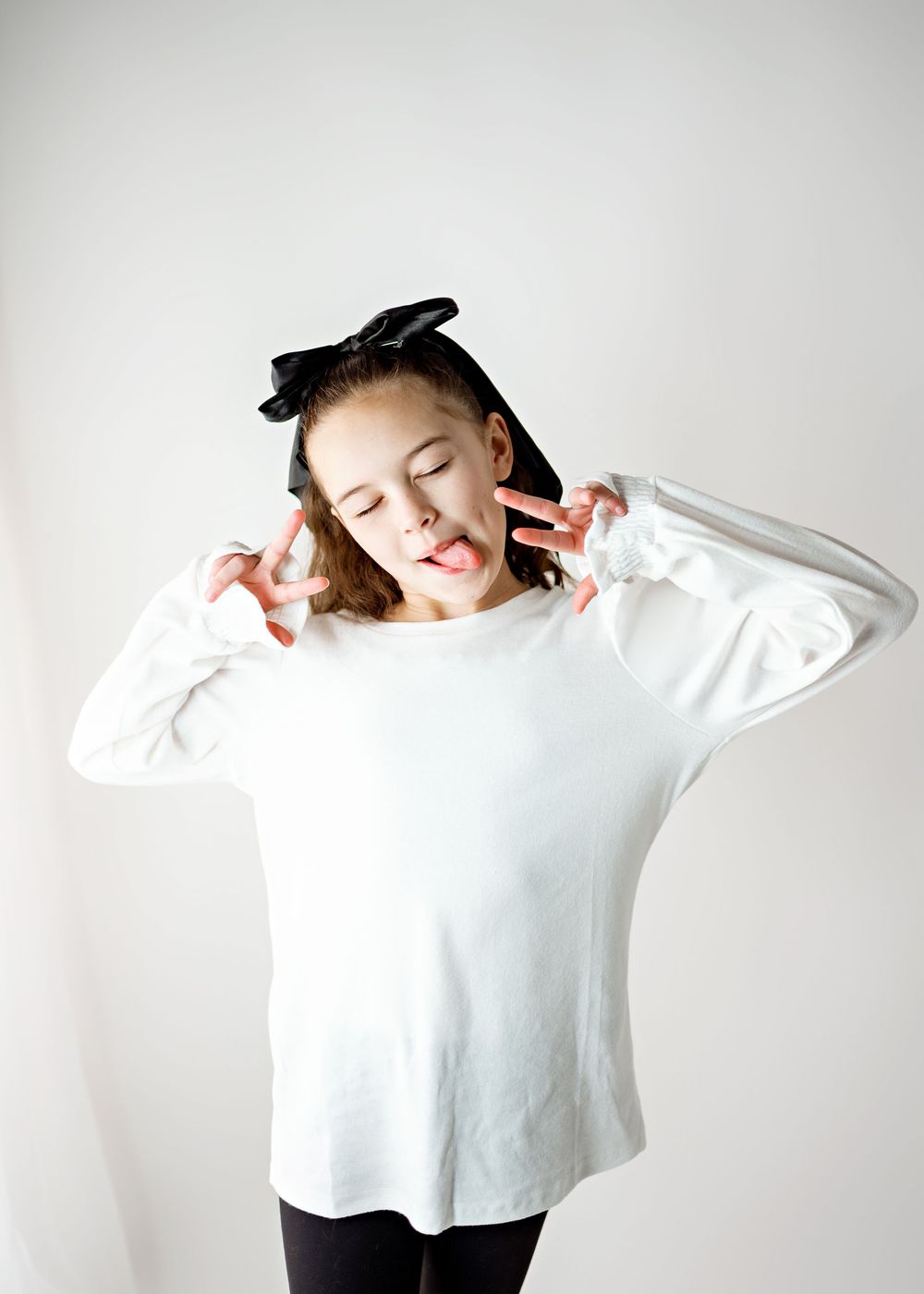 A person in a white sweater stretches and moves dynamically against a light background in a series of poses.