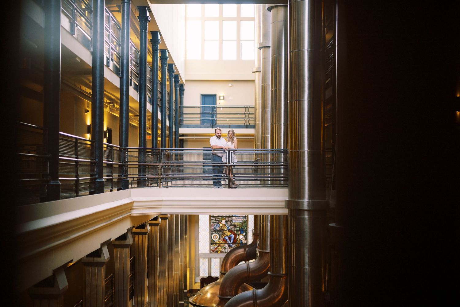 Interior view of a university library with tall bookshelves and natural light streaming through windows at golden hour.
