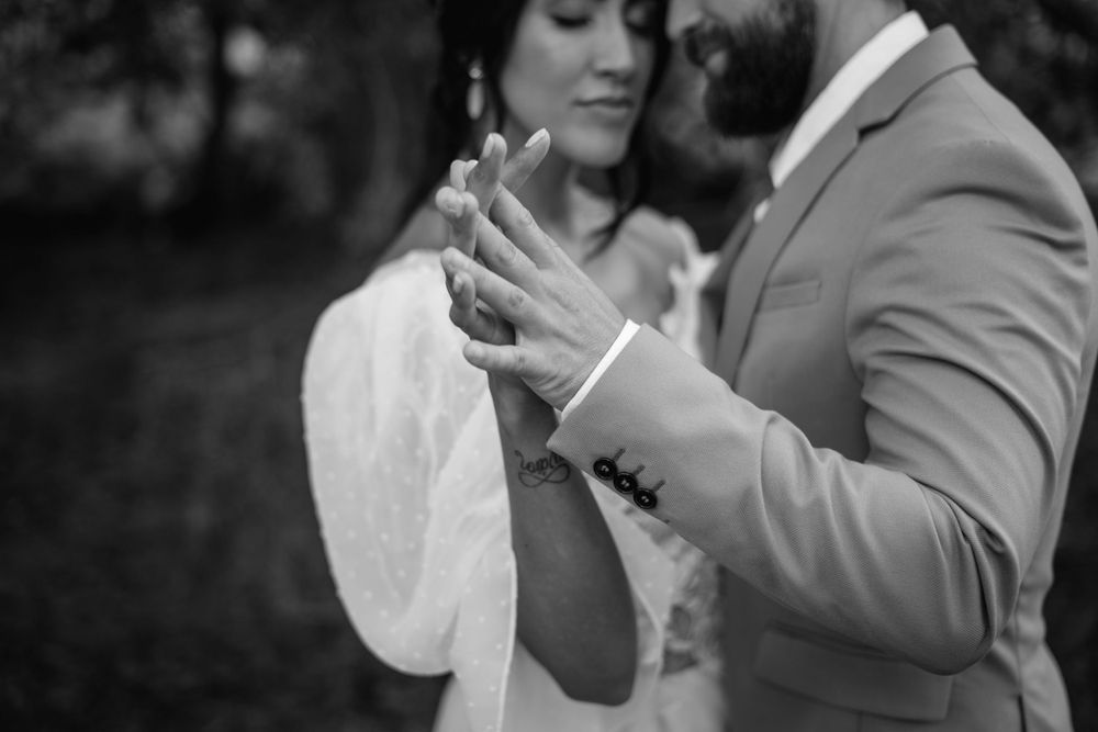 A black and white close-up of tender moments between newlyweds.
