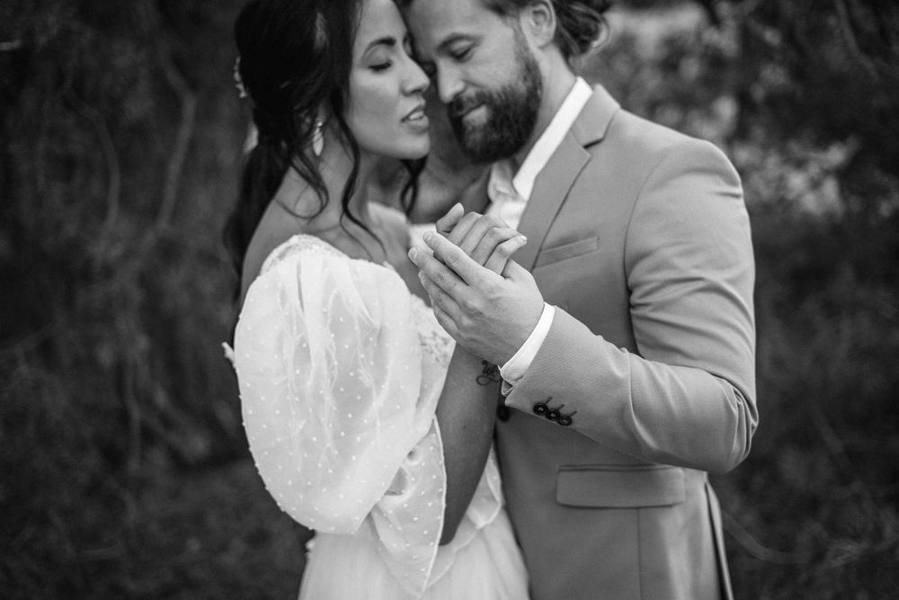 An artistic black and white portrait capturing a tender moment between newlyweds.