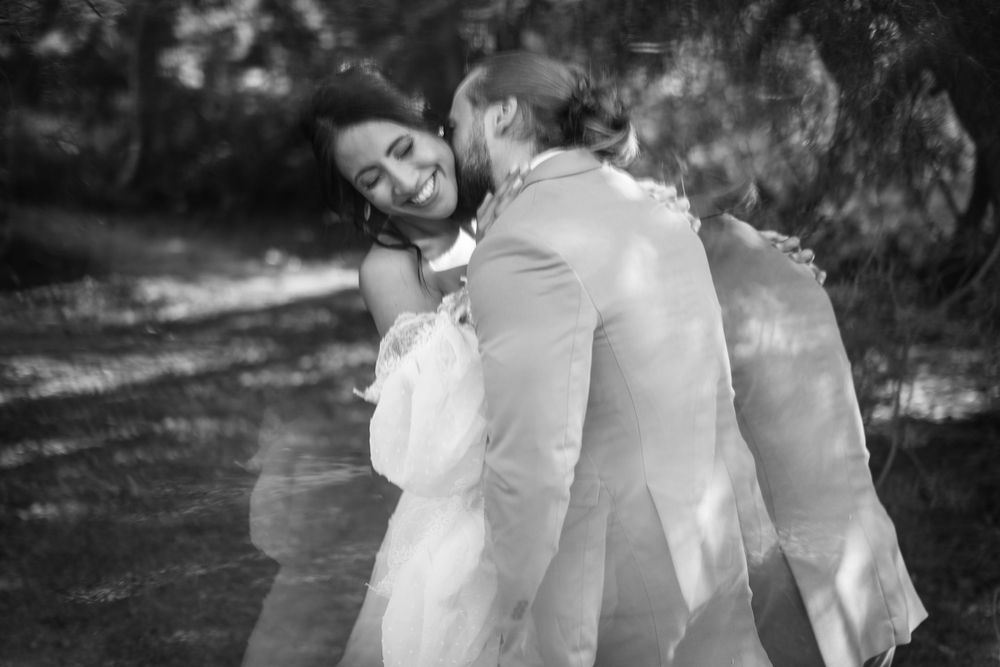 A dreamy black and white wedding photo capturing movement and joy between newlyweds.
