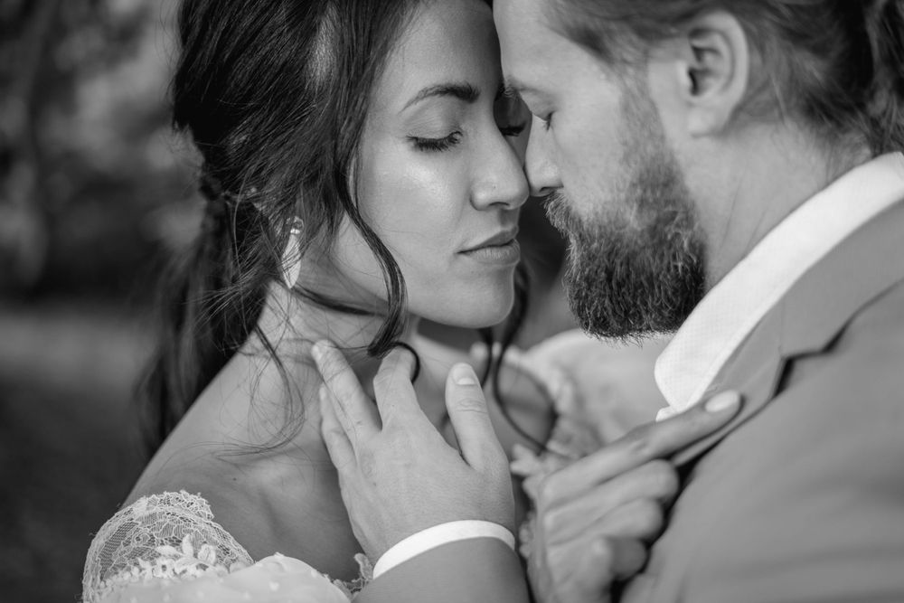 Black and white intimate portrait of newlyweds sharing a tender moment.