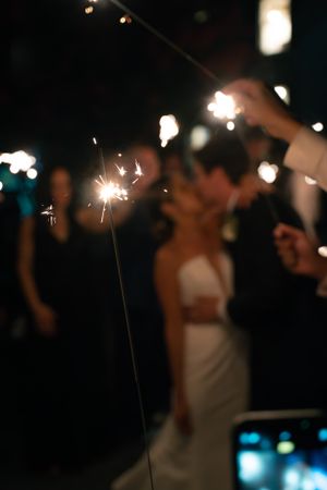 Sparkler creates magical glow during evening wedding celebration.