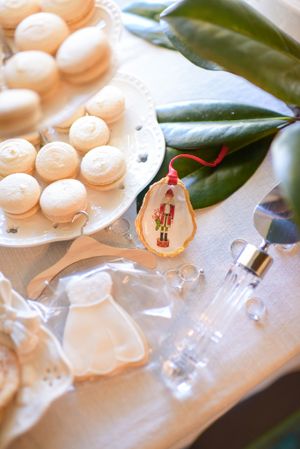 White macarons arranged on a plate with magnolia leaves and decorative elements.