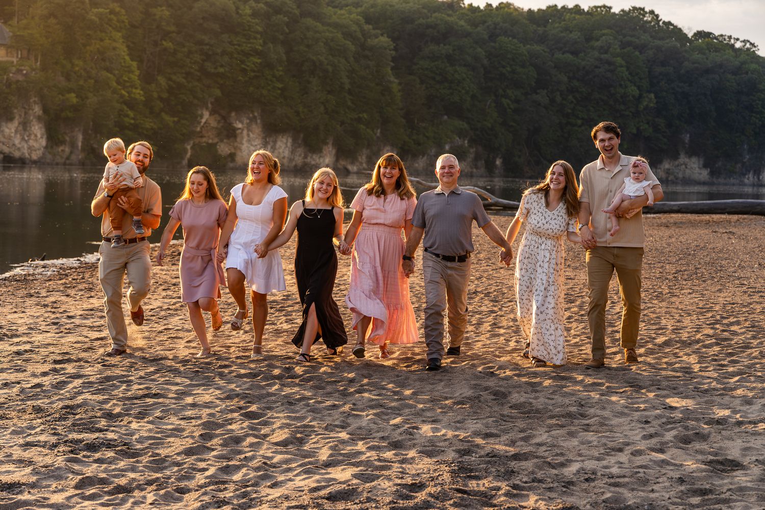 A group walks along a sandy beach at sunset, creating a panoramic series of silhouettes against the golden sky.
