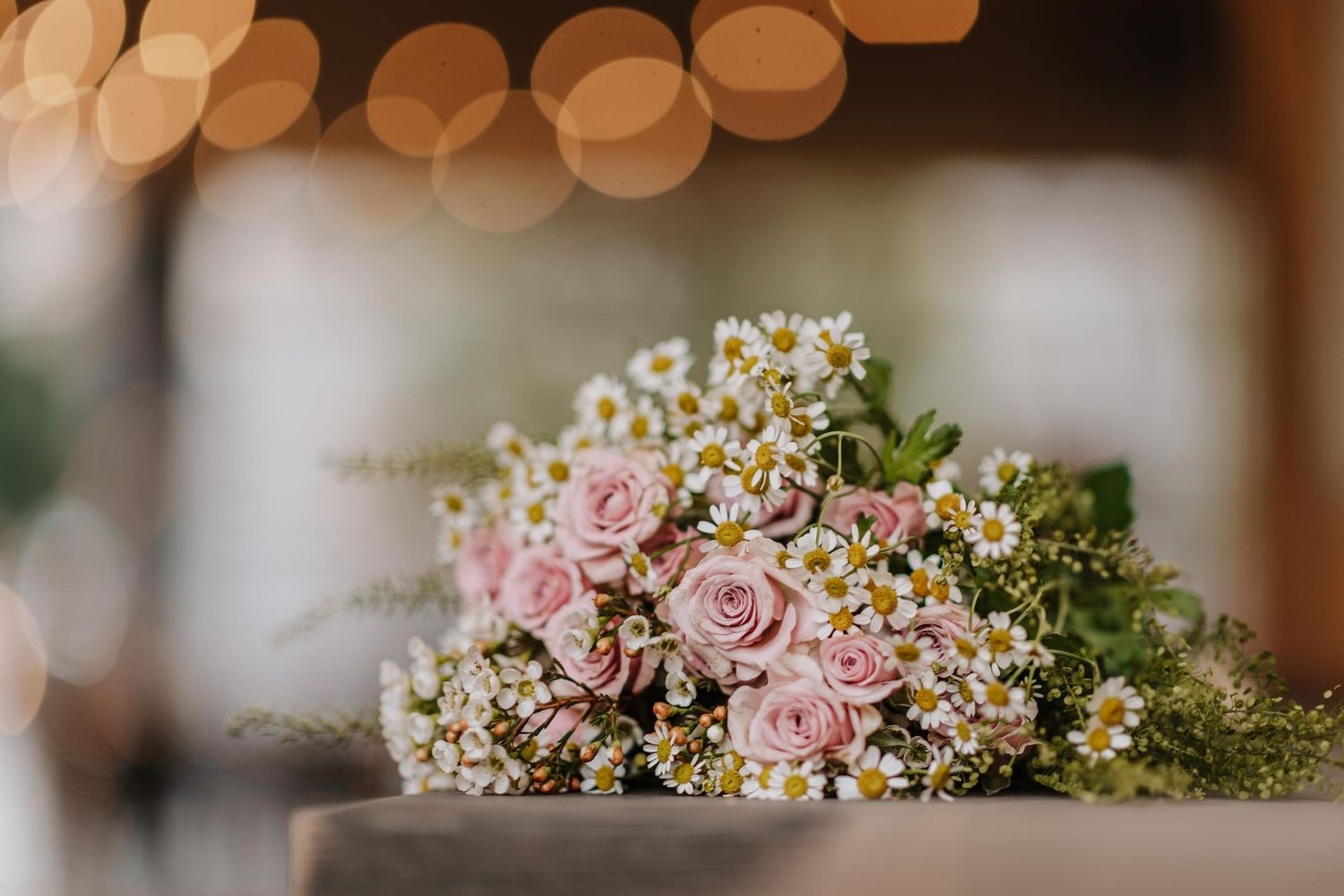 Delicate pink and white wildflower wedding bouquet with soft romantic lighting.