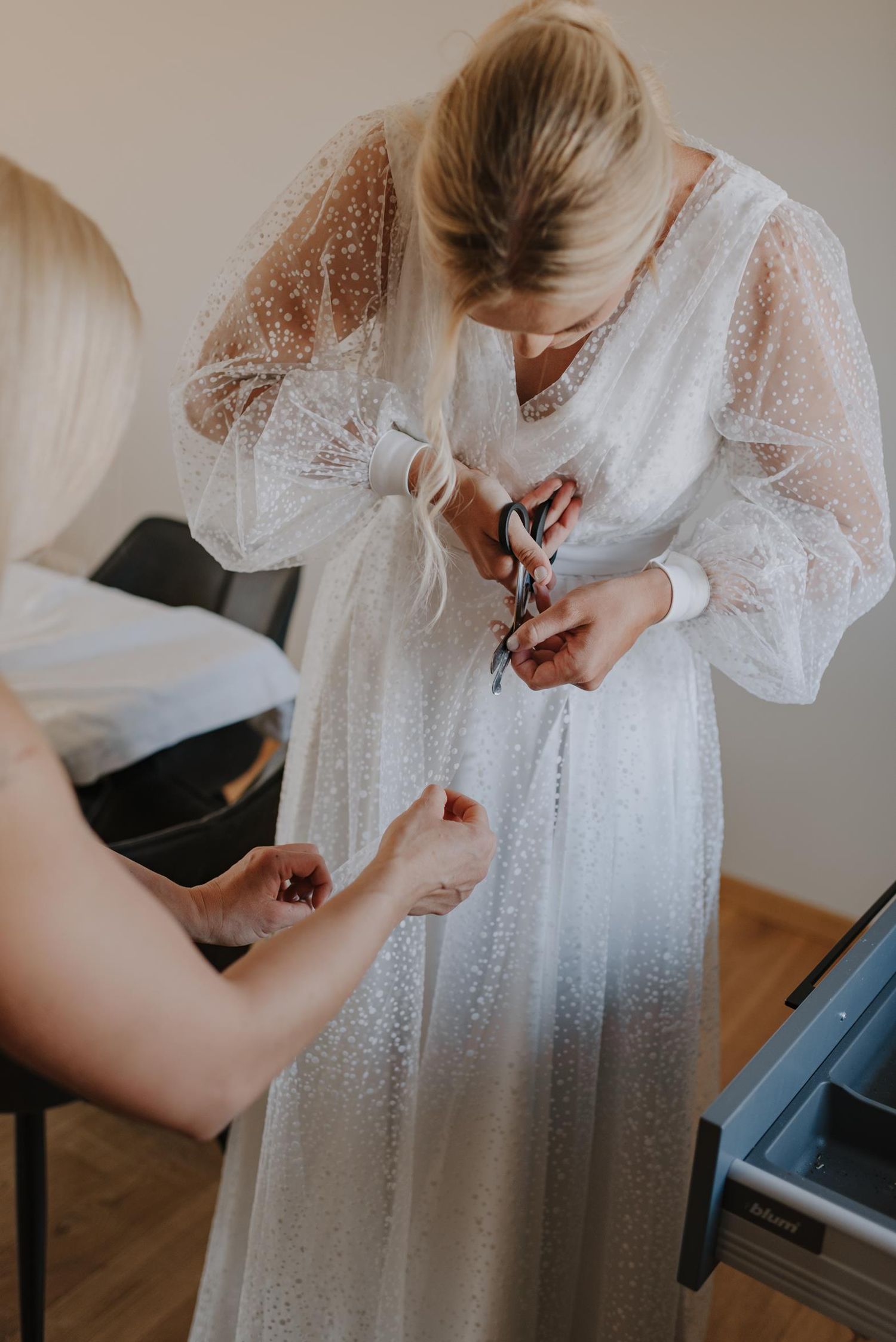 Closeup of delicate white lace dress details with buttons.