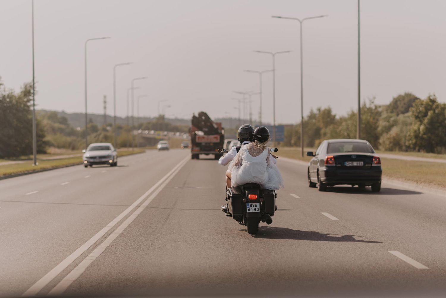 Motorcycle cruising down empty highway on sunny day.