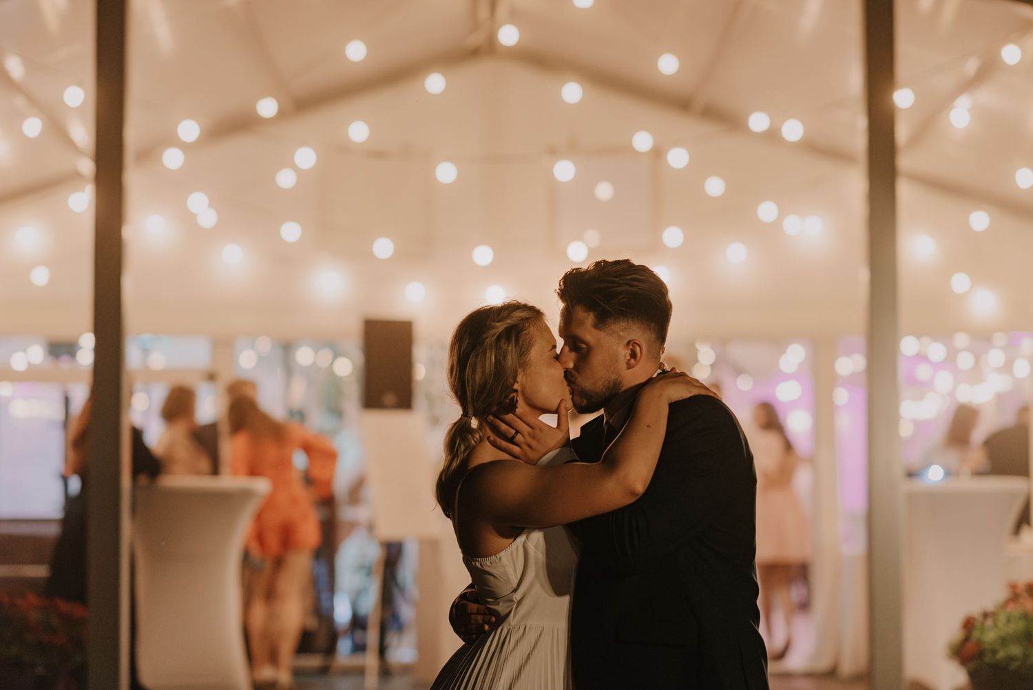 String lights create a romantic glow during an evening wedding reception.
