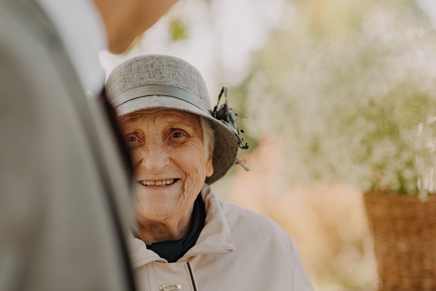 Senior couple sharing an emotional embrace during a garden wedding celebration.