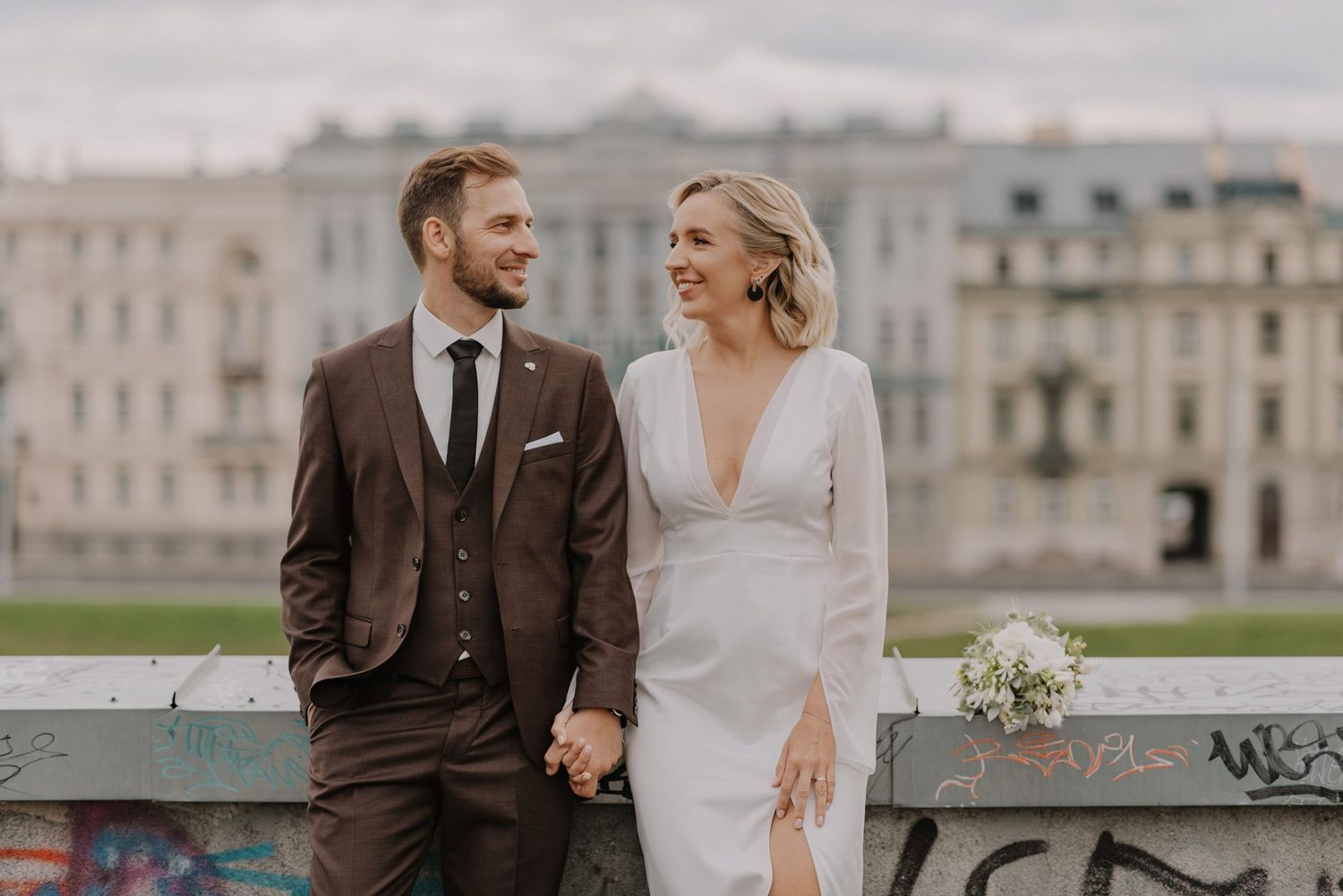 Wedding couple posing in front of grand historic buildings on their special day.