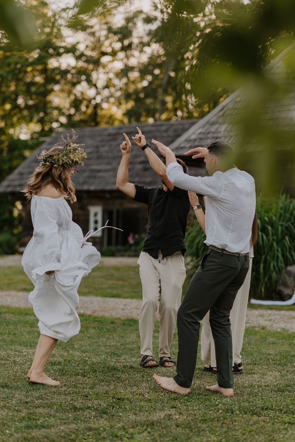 Joyful wedding celebration in a garden setting with dancing and laughter during golden hour.