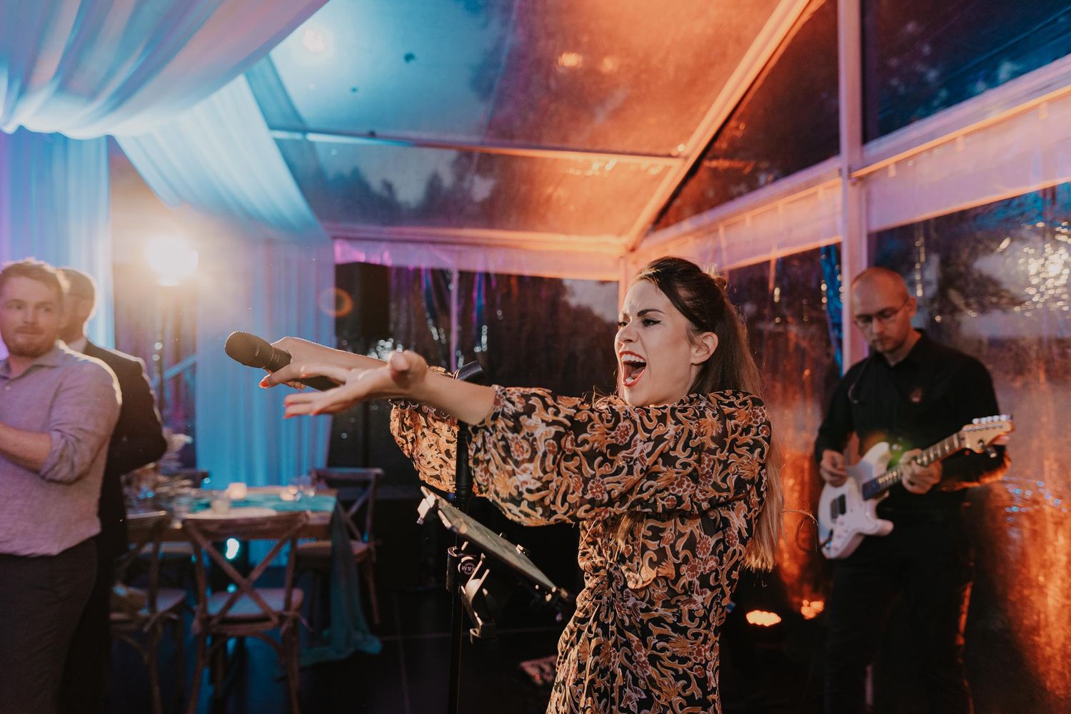 Wedding reception venue illuminated with dramatic blue and orange lighting effects.
