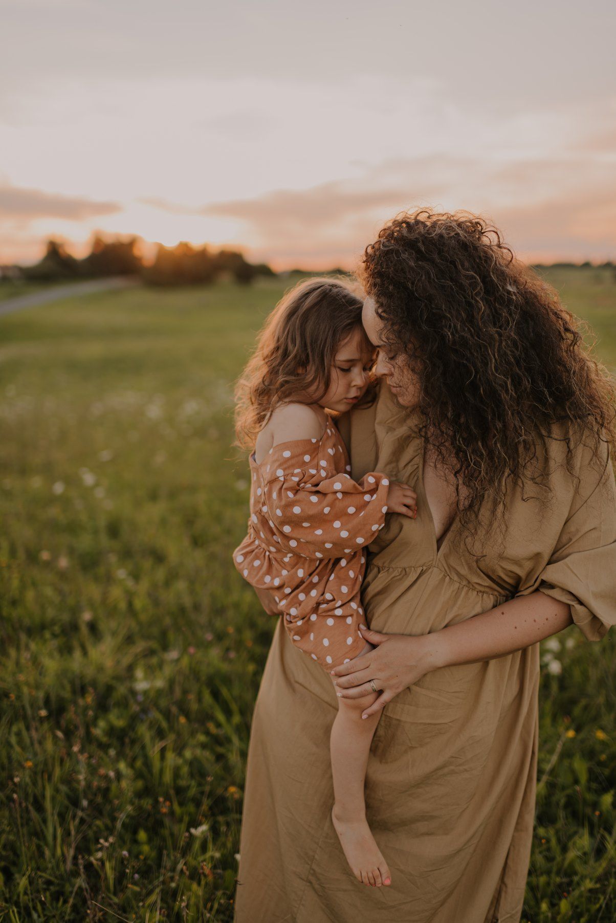 Tender moment captured in wildflower field during golden hour.