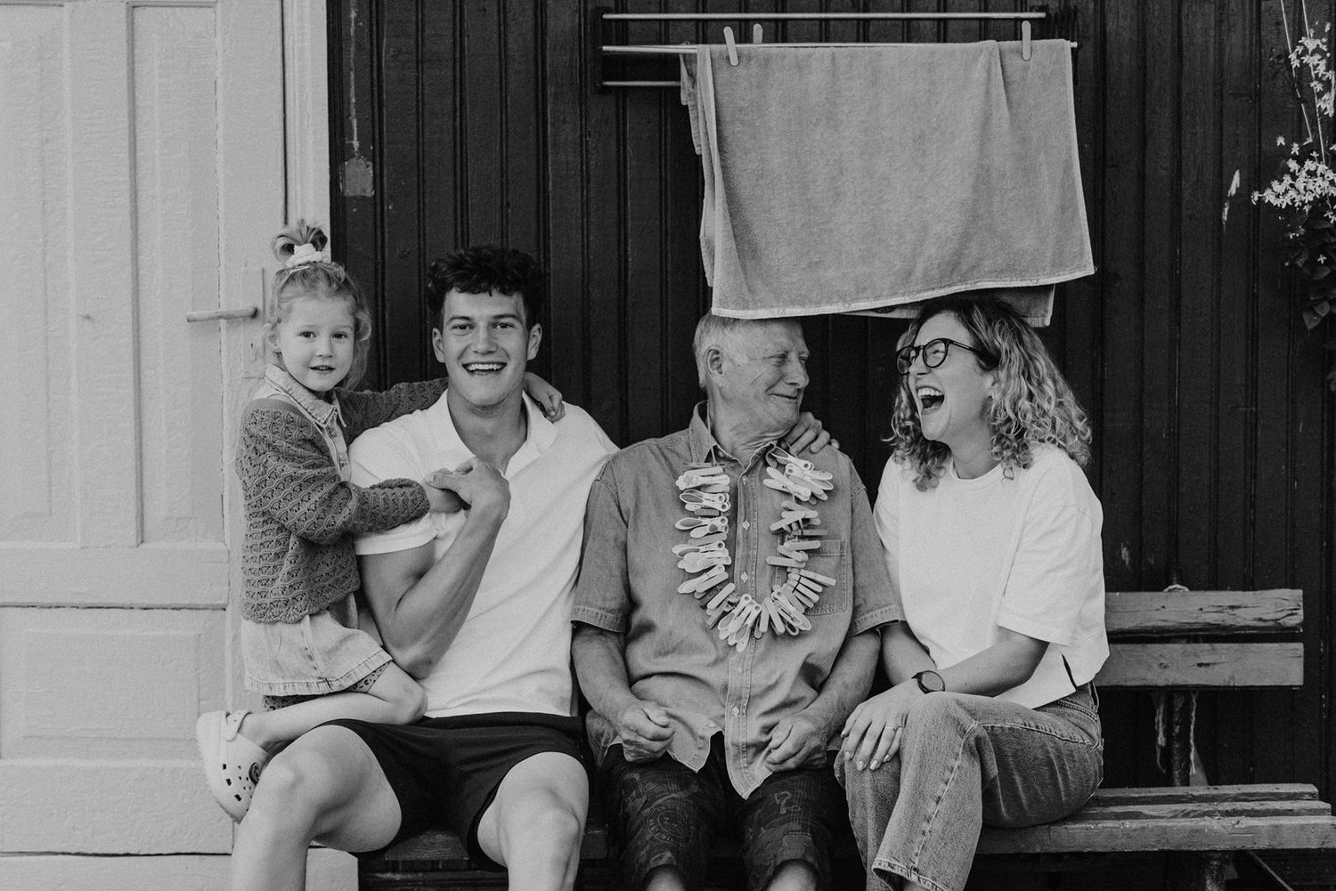 Black and white portrait of family members sitting on porch steps.