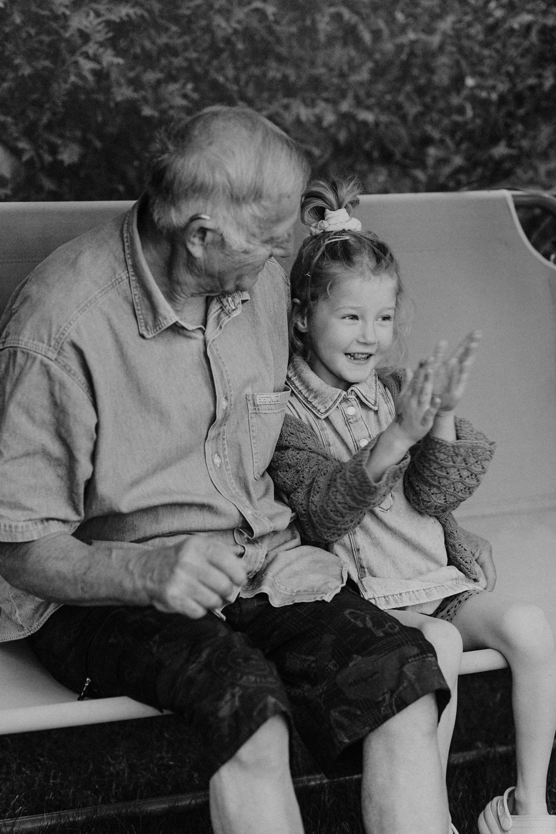 Black and white photograph capturing tender moments between family members on a couch.