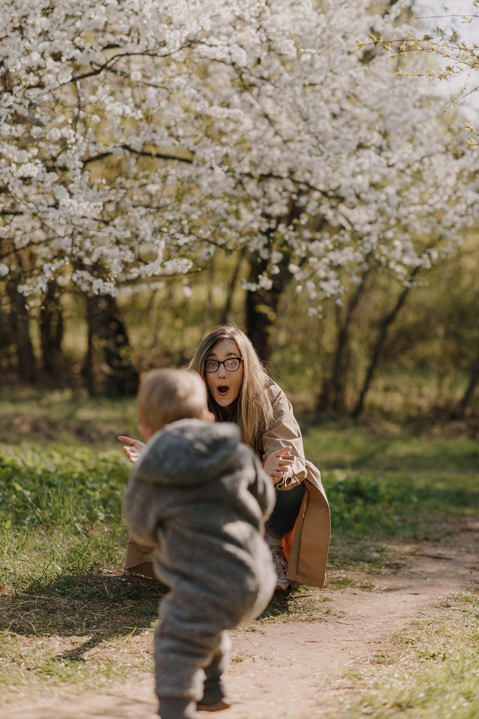 Playful moments captured under flowering cherry trees during springtime.