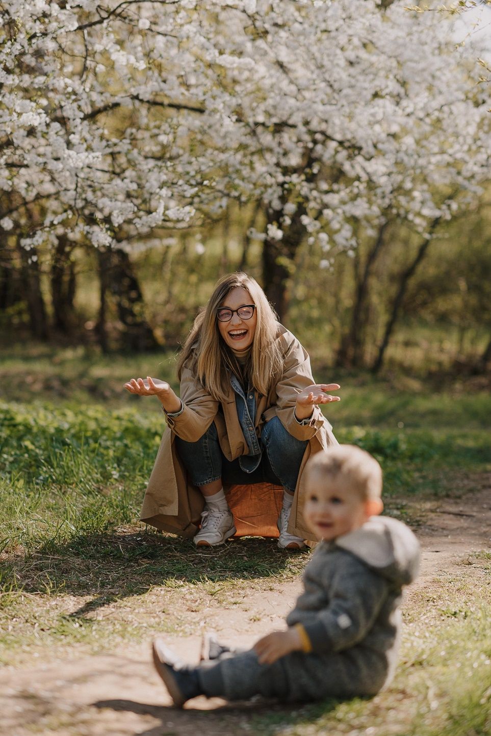 Candid family photos taken beneath beautiful white cherry blossoms.