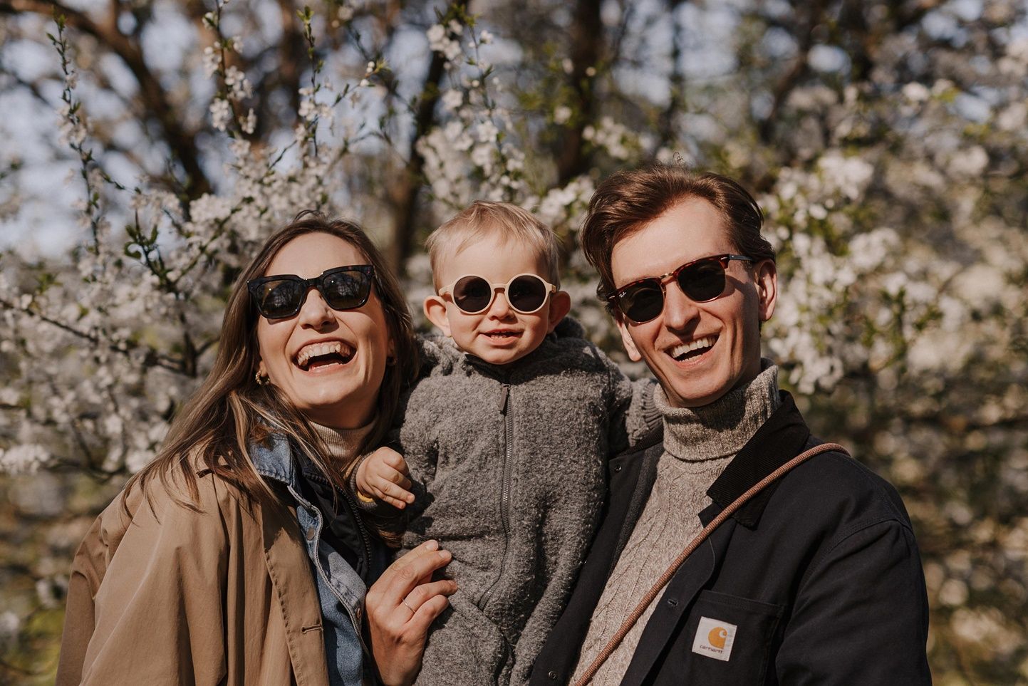 Friends enjoying a sunny autumn day wearing sunglasses and casual attire outdoors.