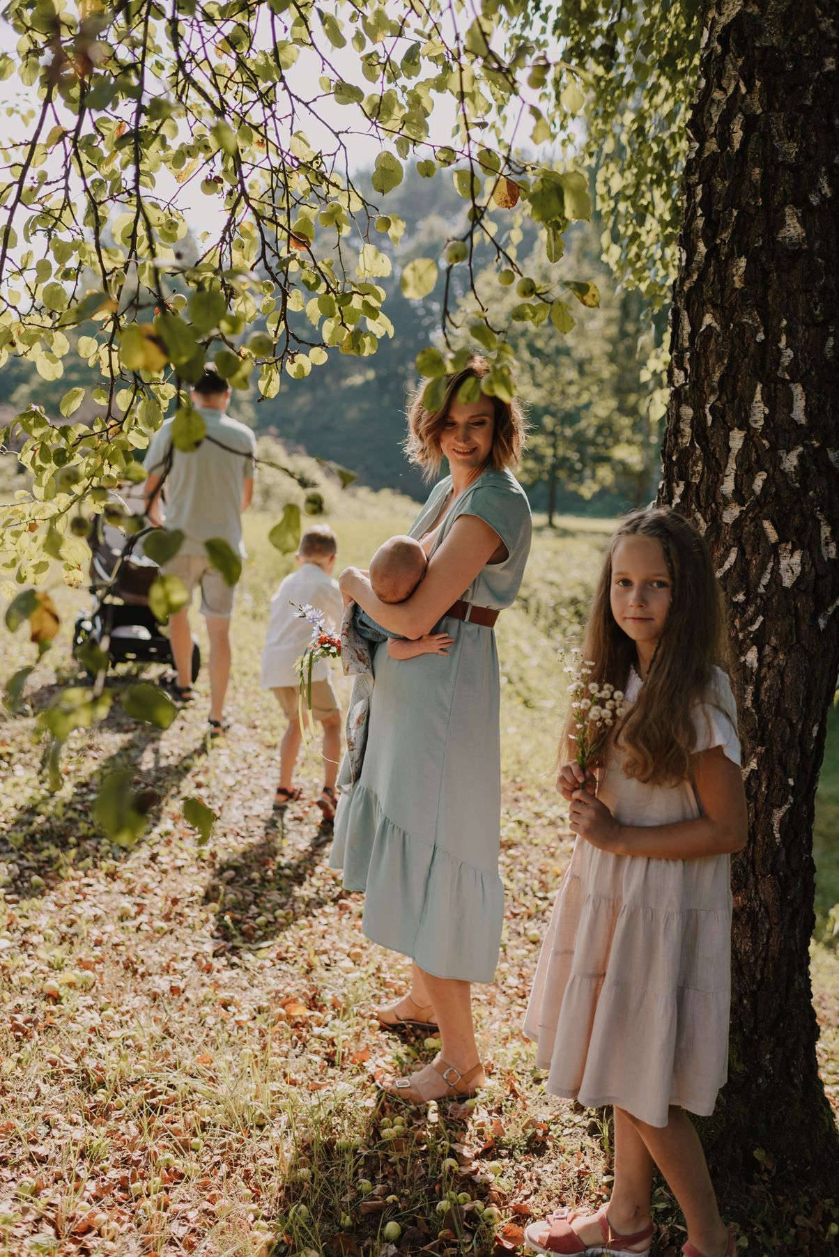 Sun-drenched family photos captured beneath trees with dappled light filtering through branches.