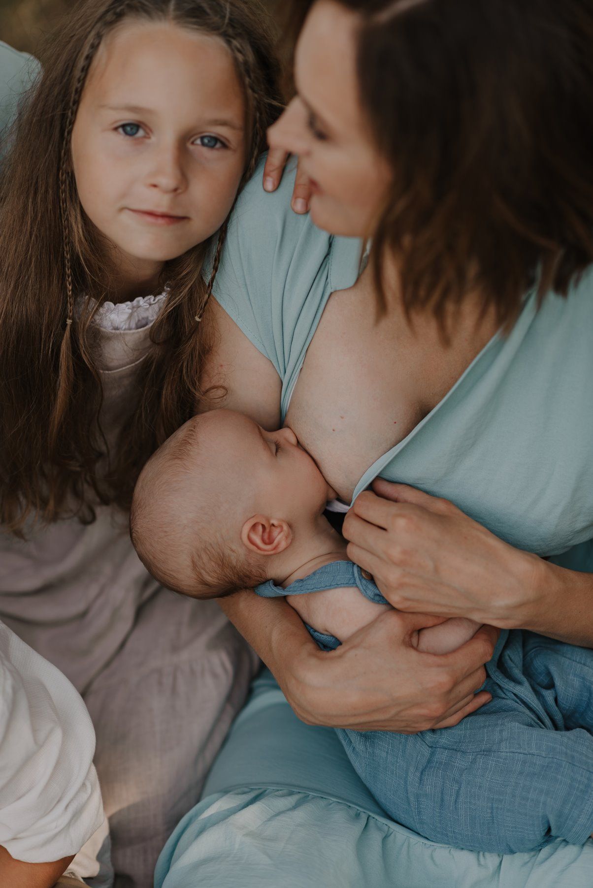 Tender family moment captured in soft natural light during an outdoor portrait session.