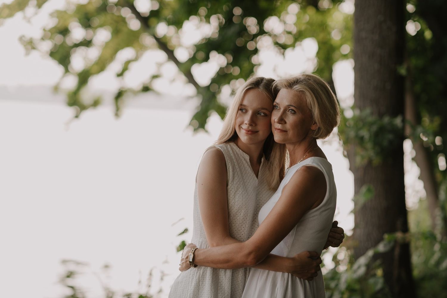 Dreamy outdoor portrait session with soft bokeh lighting effects in a wooded setting.