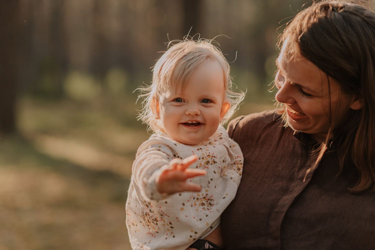 Tender family moment captured in warm sunlight as parent and child share a close embrace.