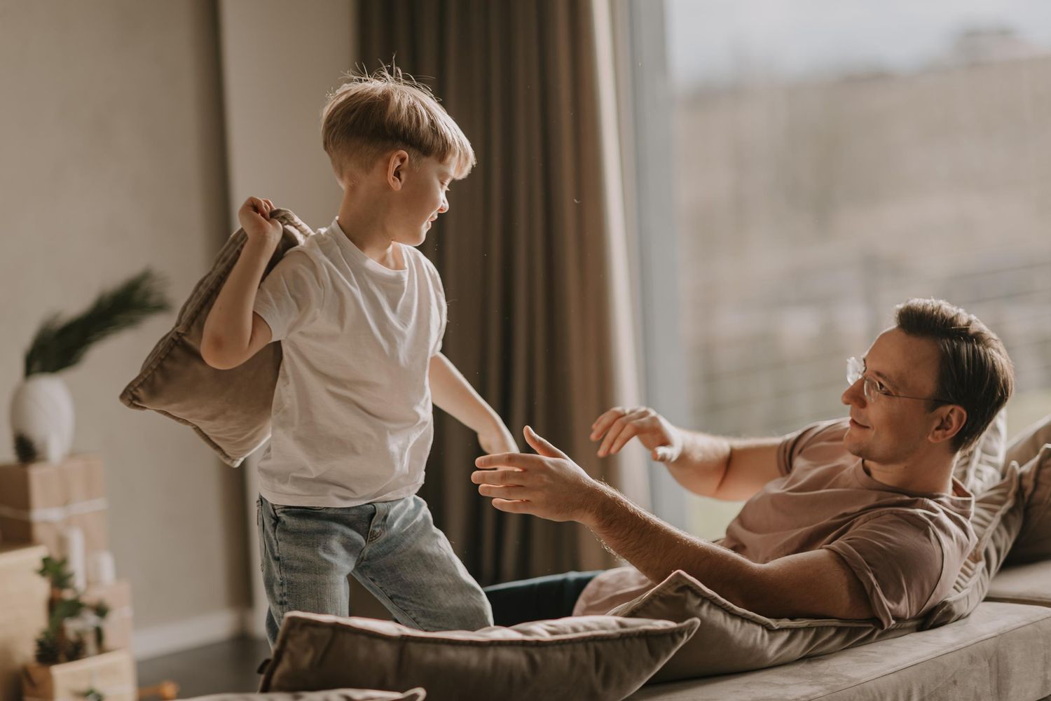 Playful family moment on a couch with energetic movement and laughter.