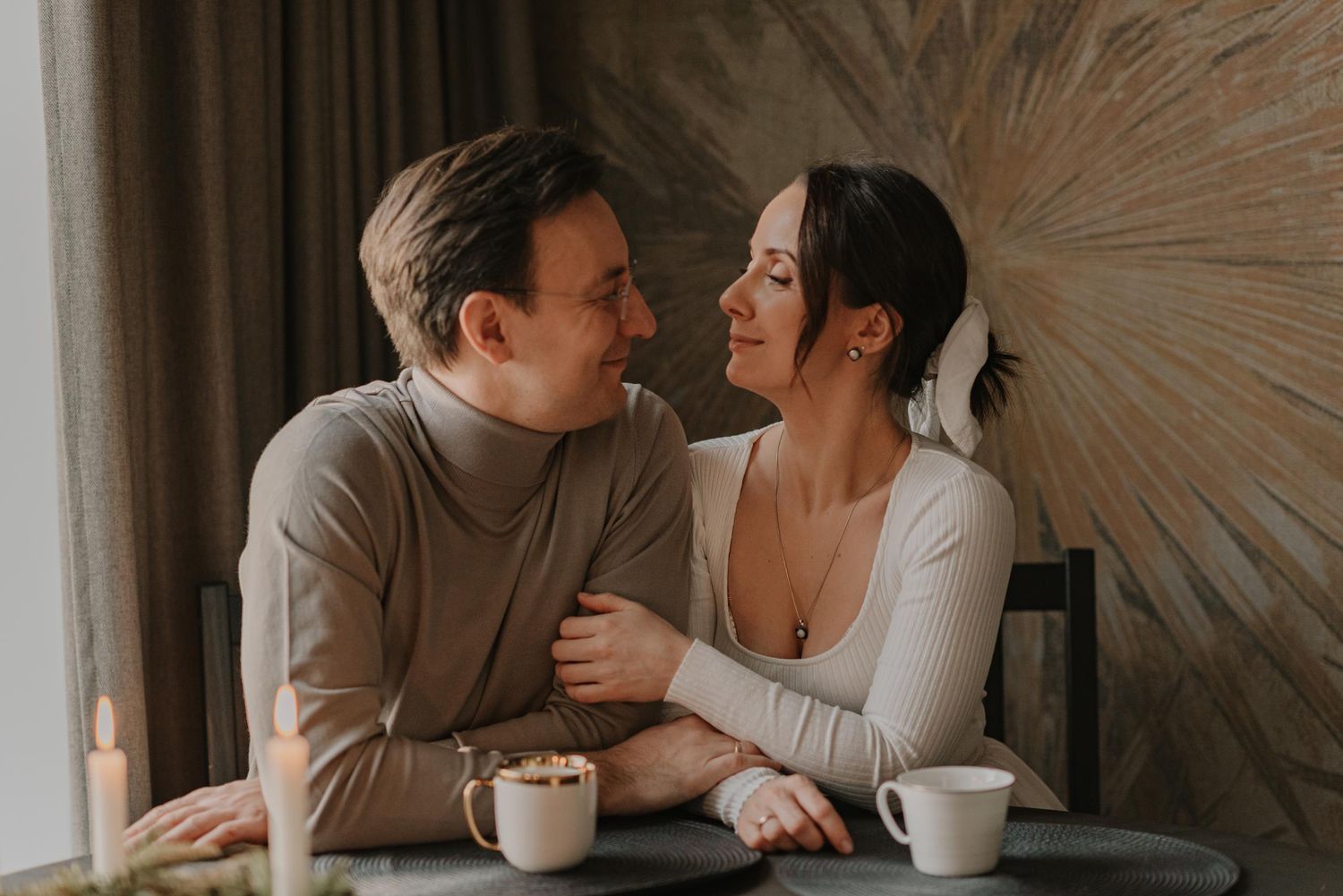 Romantic couple sharing an intimate moment over coffee in a sunlit room.