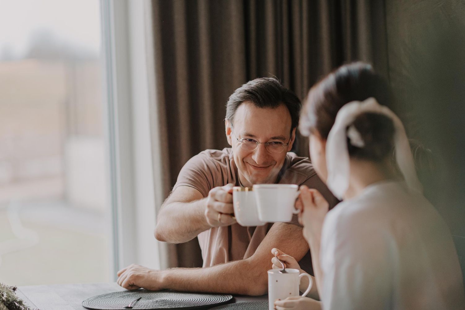 Family members sitting together at a table sharing coffee and conversation.