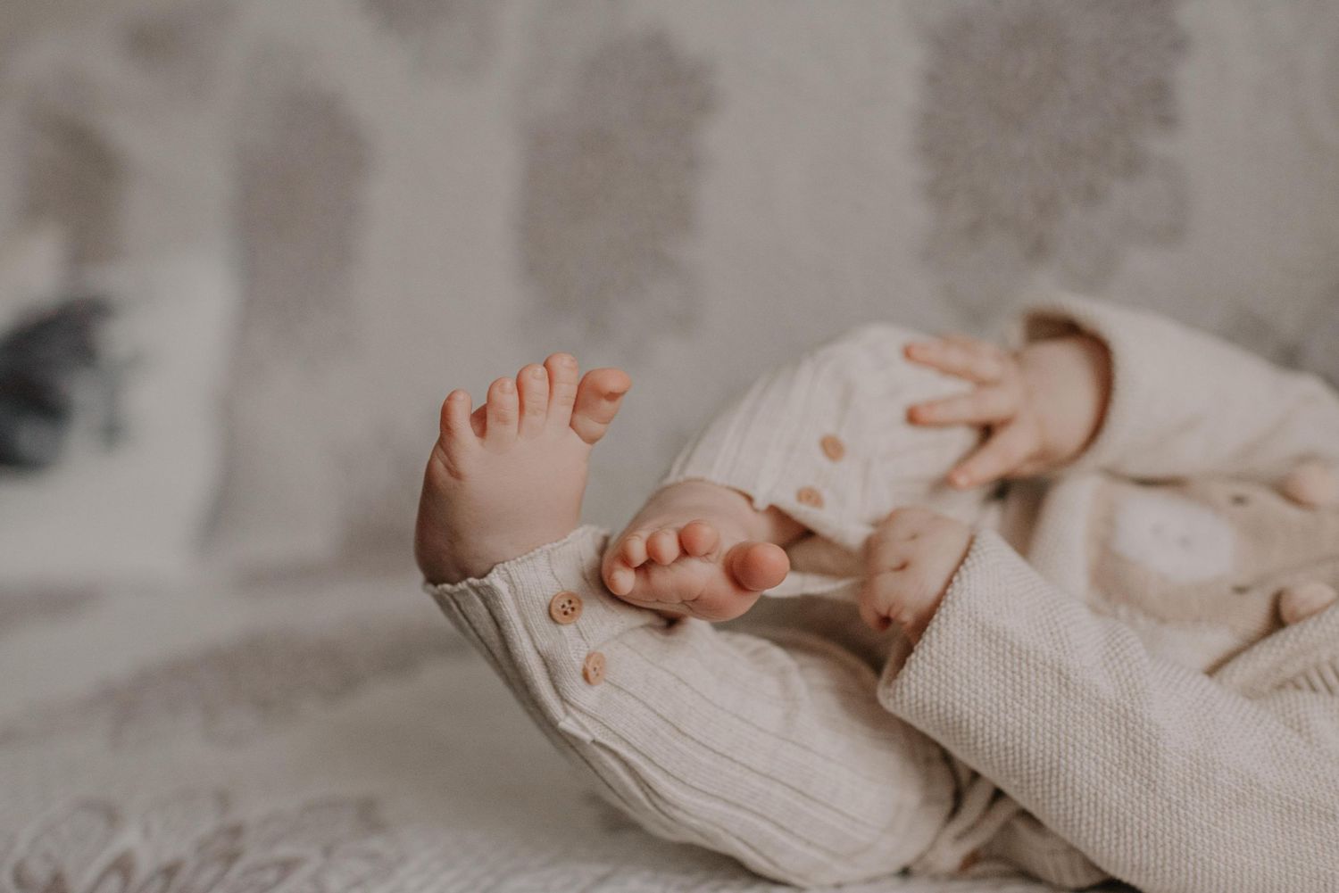 Parent holding baby while standing in warmly lit interior space.