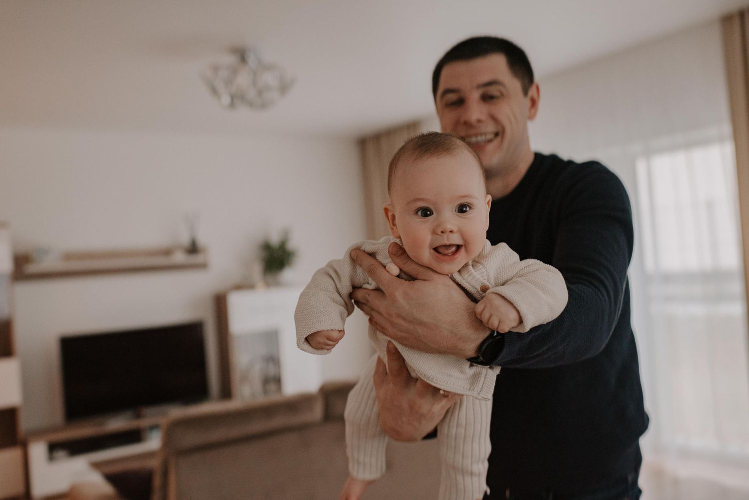 Family playfully interacts during mealtime in modern home setting.