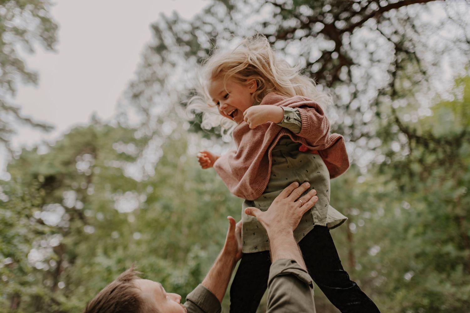 Playful moment captured during outdoor family photography session in natural setting.