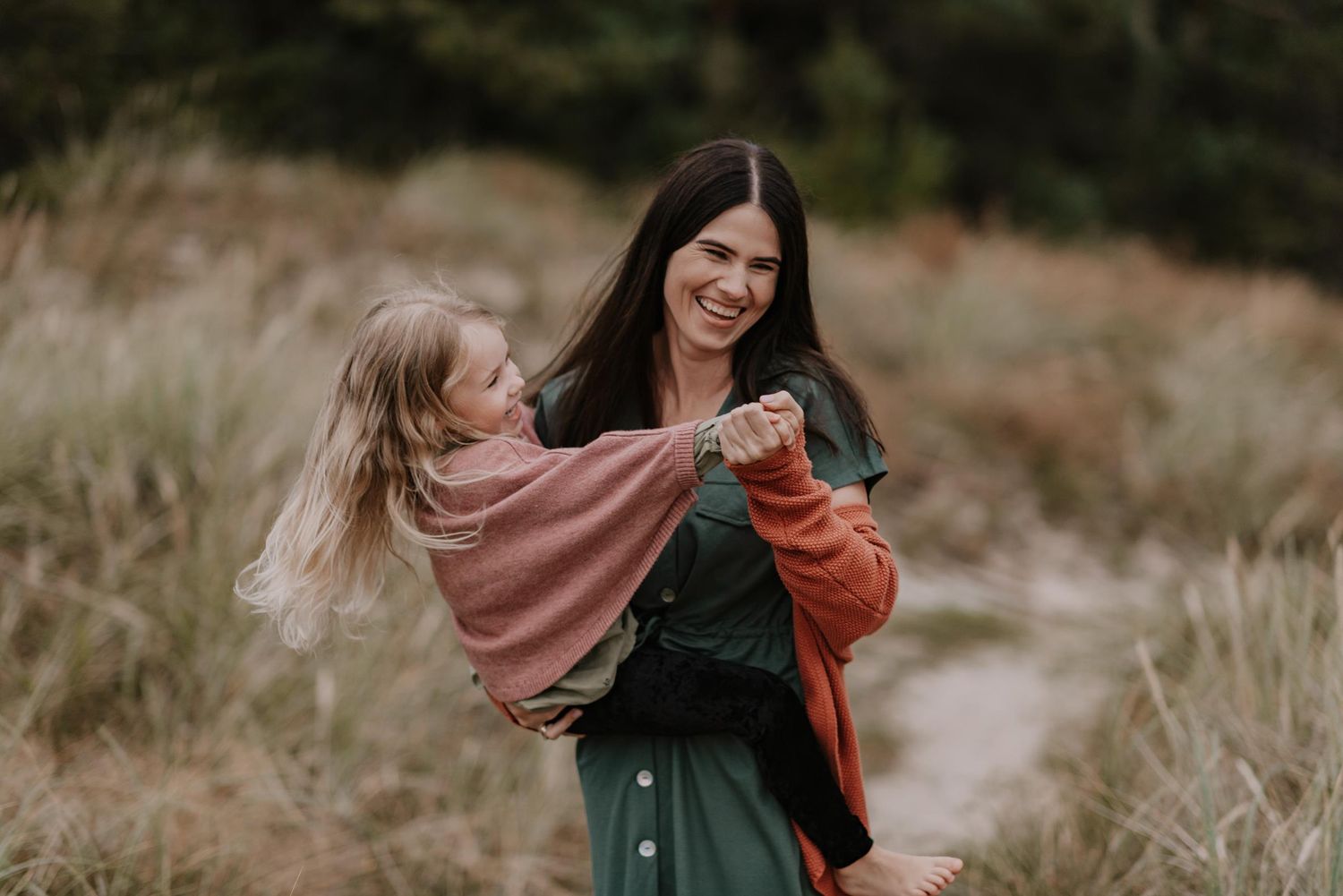 Family enjoying golden hour in a field during lifestyle photoshoot.