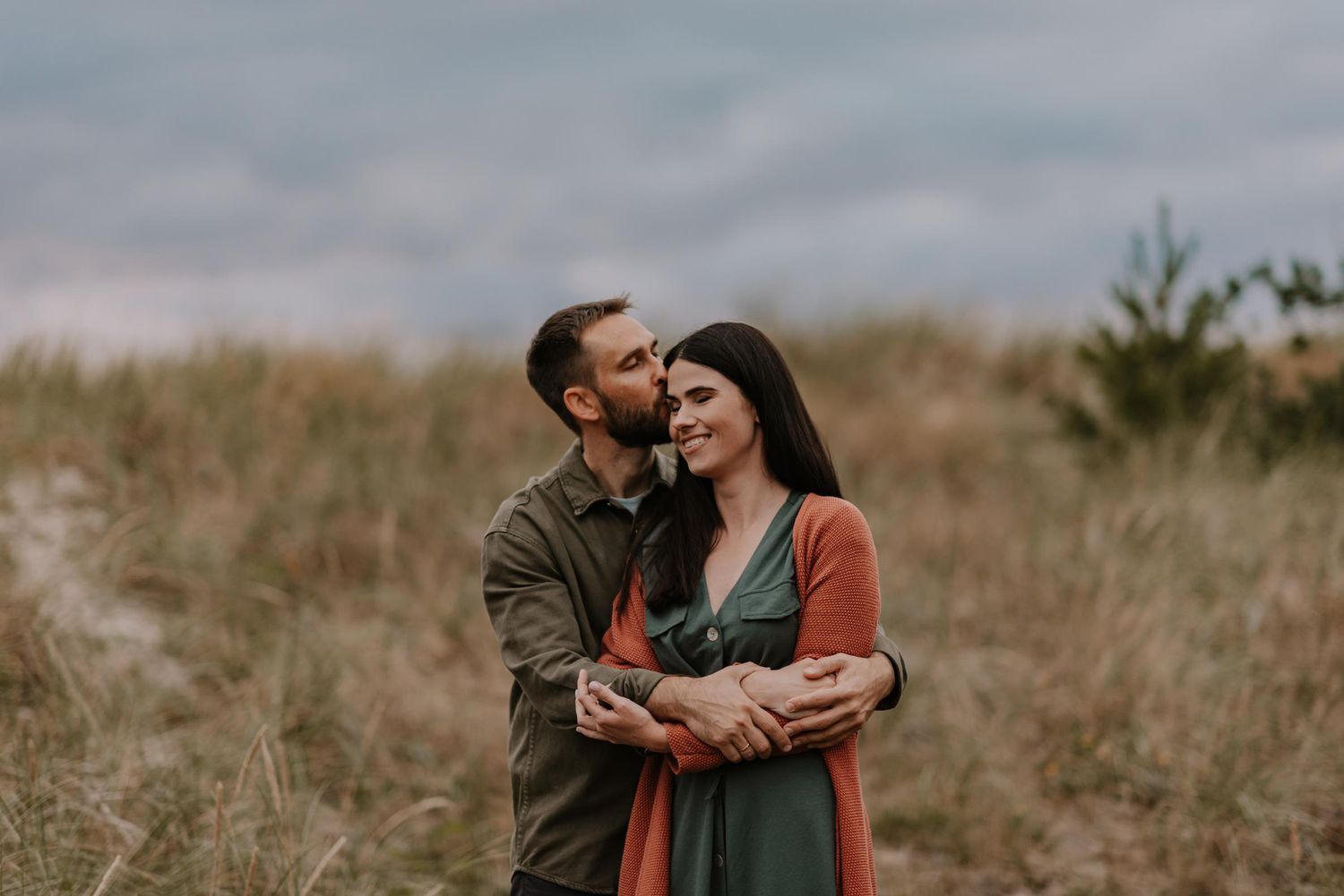 Intimate family moment captured in natural setting during sunset.
